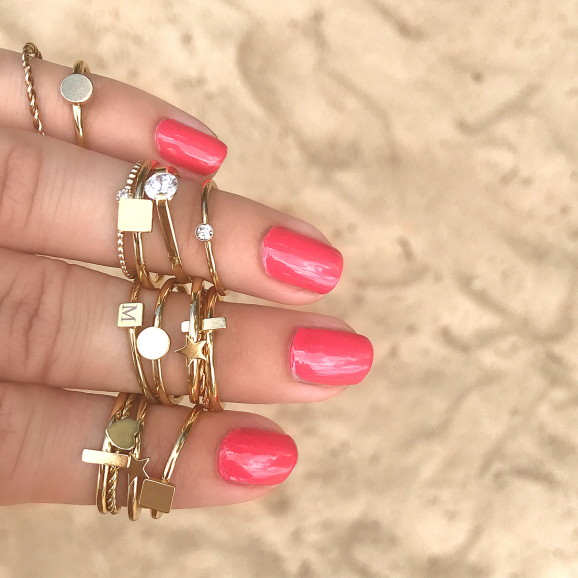Gouden ringen om de hand met roze nagellak