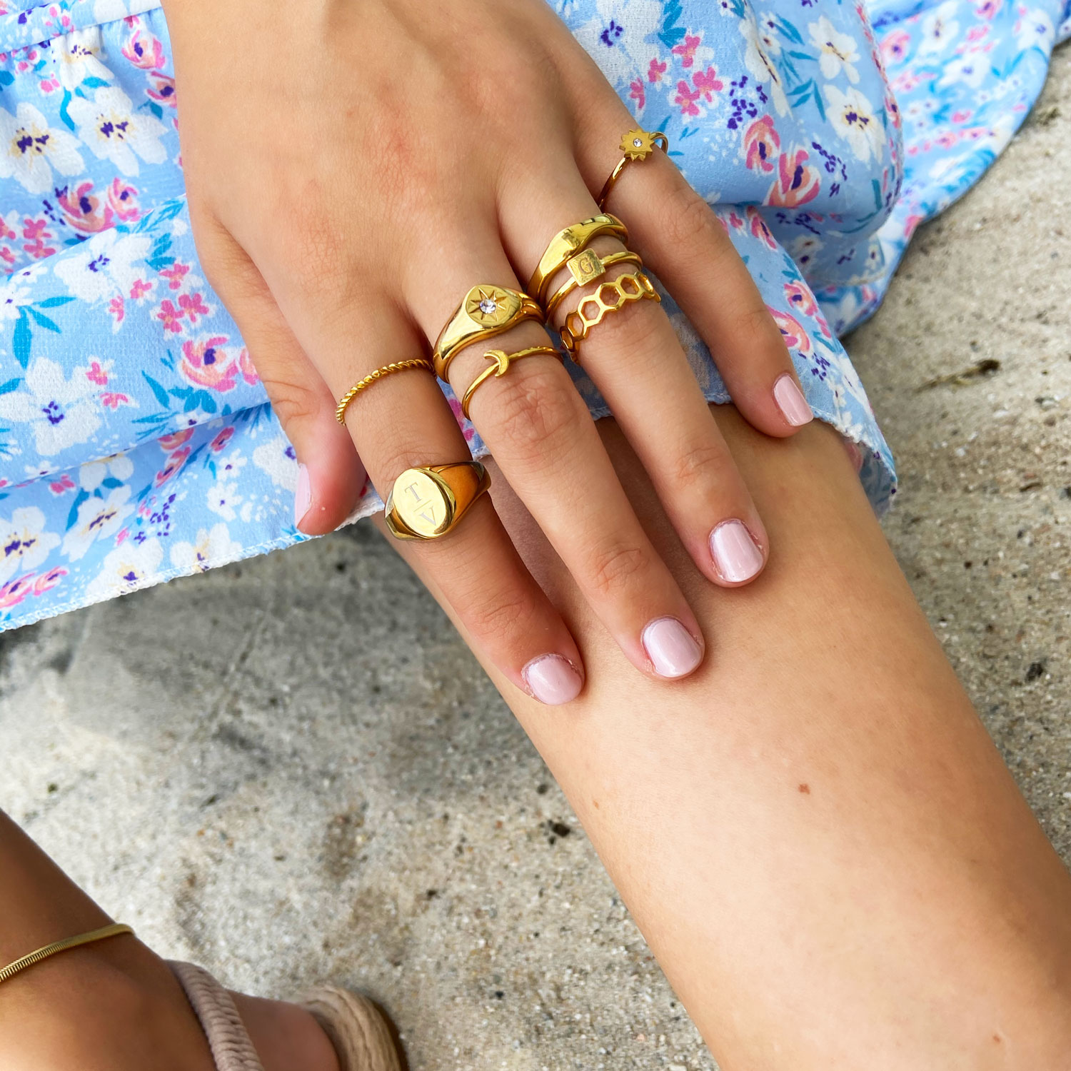 Mooie beachlook met goudkleurige ringen om de hand