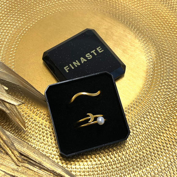 Golvende gouden ring in een sieradendoosje op een gouden plaatje