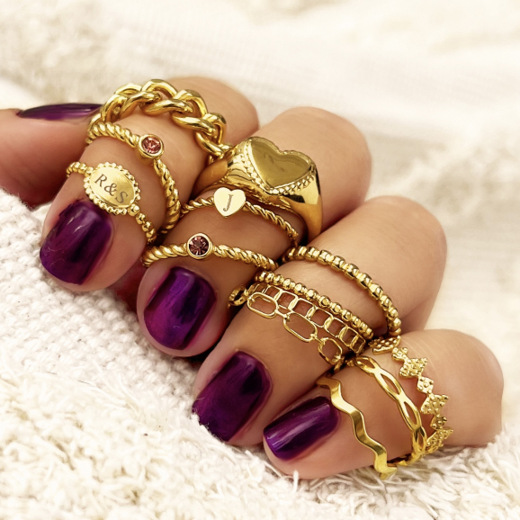 Gouden ringen gemixt met rode nagels