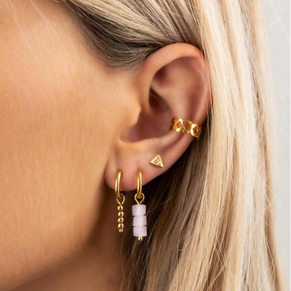 Model draagt lila oorbellen in oor