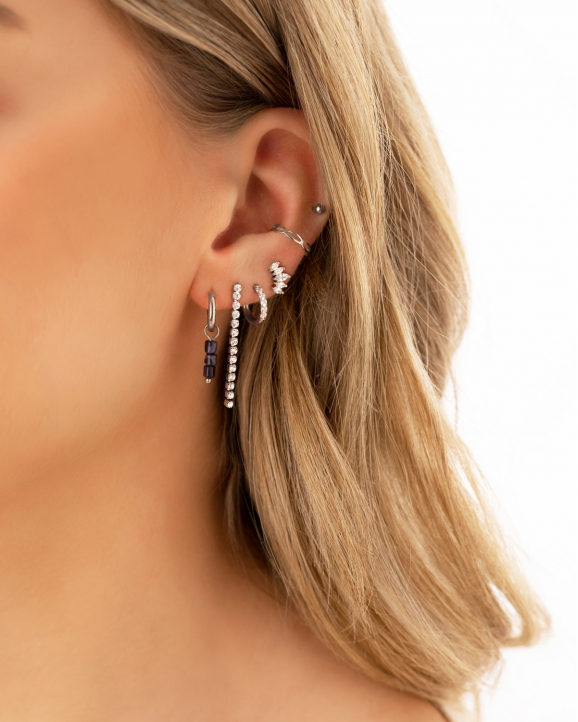 Mix van zilveren oorbellen gedragen door model