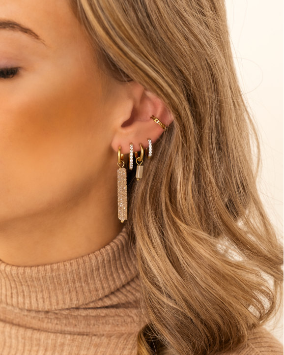 Model draagt gouden earparty met steentjes