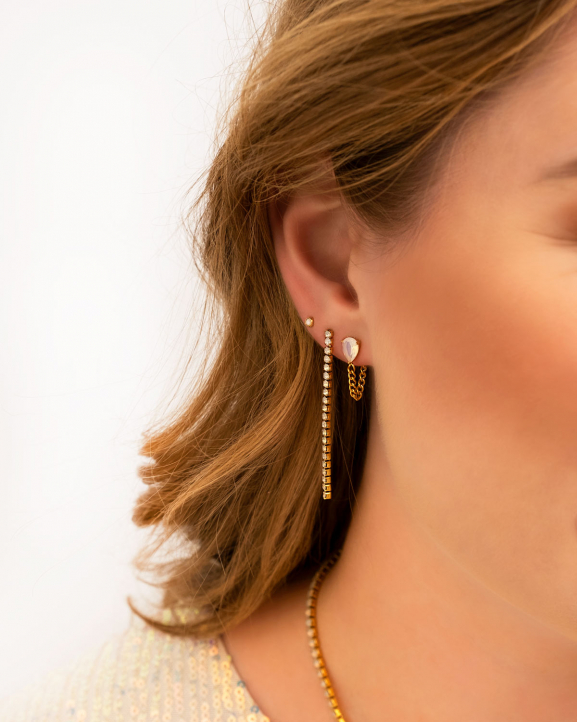 Model draagt earparty met gouden oorbellen met opal steentjes