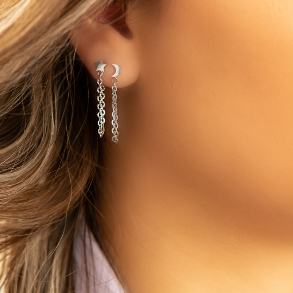 Mooie zilverkleurige ketting oorbellen in het oor van het model