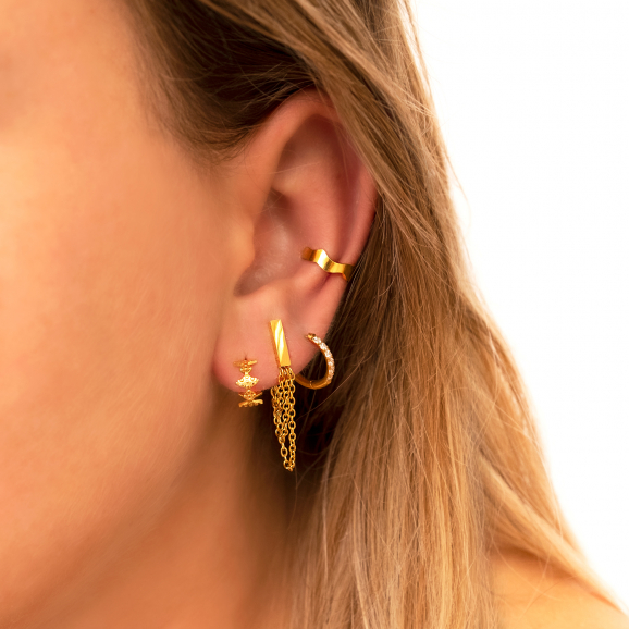 Model draagt mix van goudkleurige oorbellen