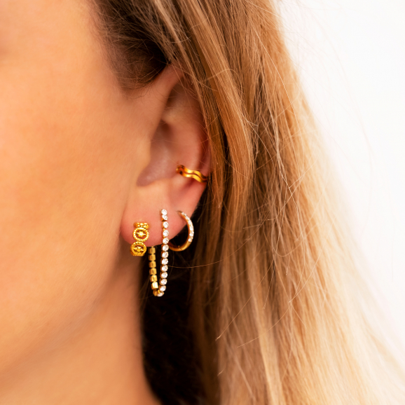 Vrouw draagt earparty met gouden oorbellen