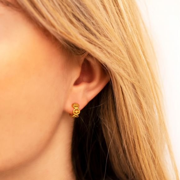 Gouden oorringetjes met patroon in oor