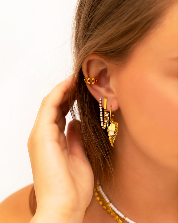 Model draagt mix van gouden oorbellen