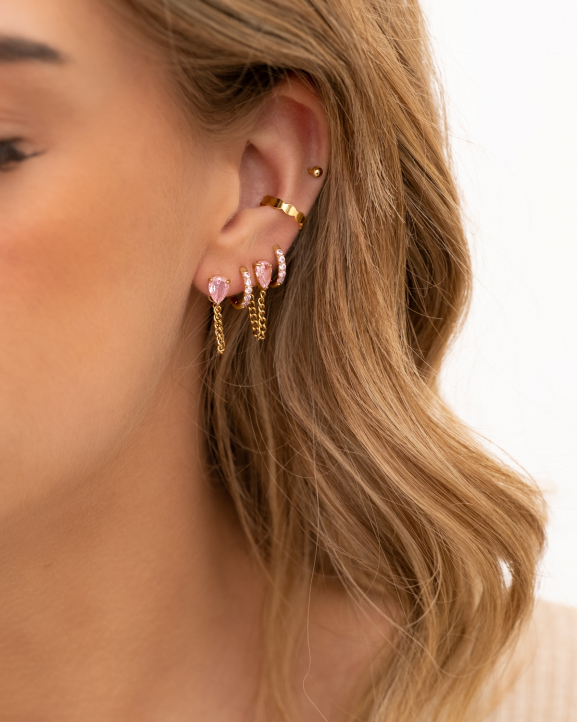 Model draagt gouden en roze oorbellen mix