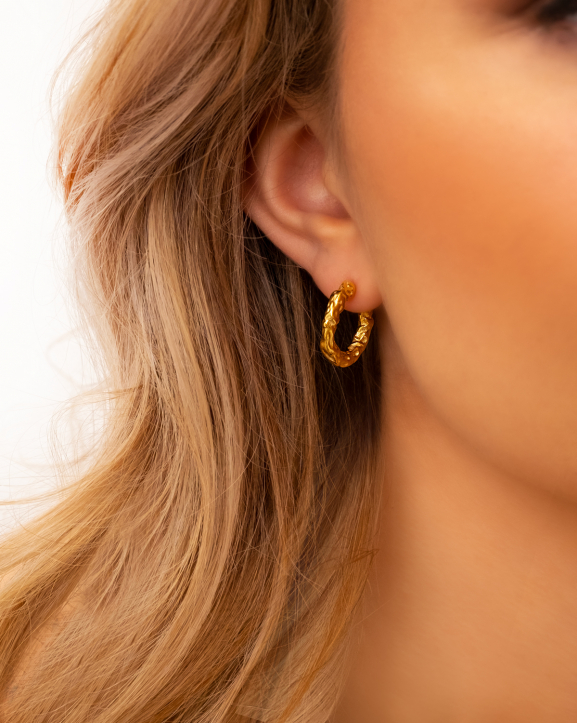 Model draagt Hammered hoops goudkleurig in oor