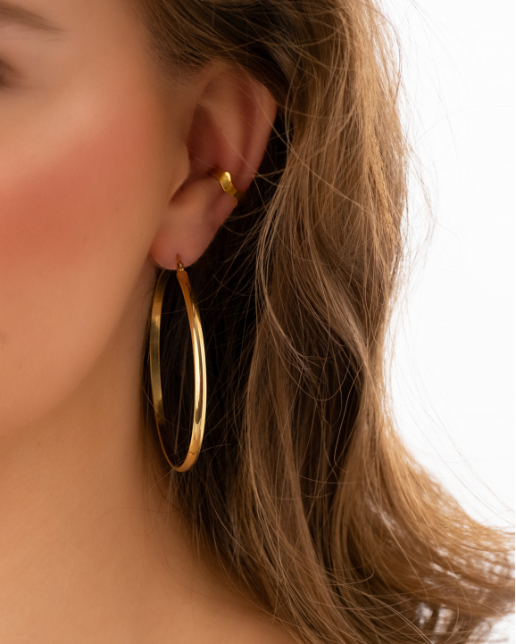 Model draagt big hoop earrings goldplated in oor