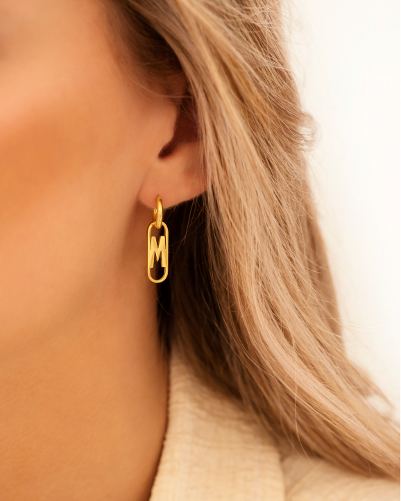Gouden letter oorbellen bij model