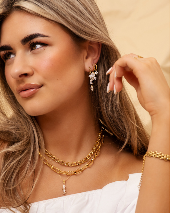 Model draagt gouden sieraden met steentjes