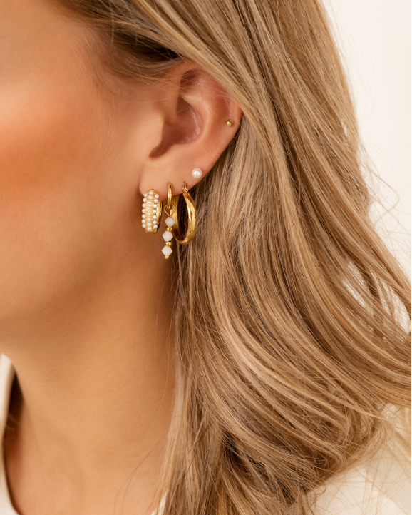 Model draagt gouden earparty met nude steentjes