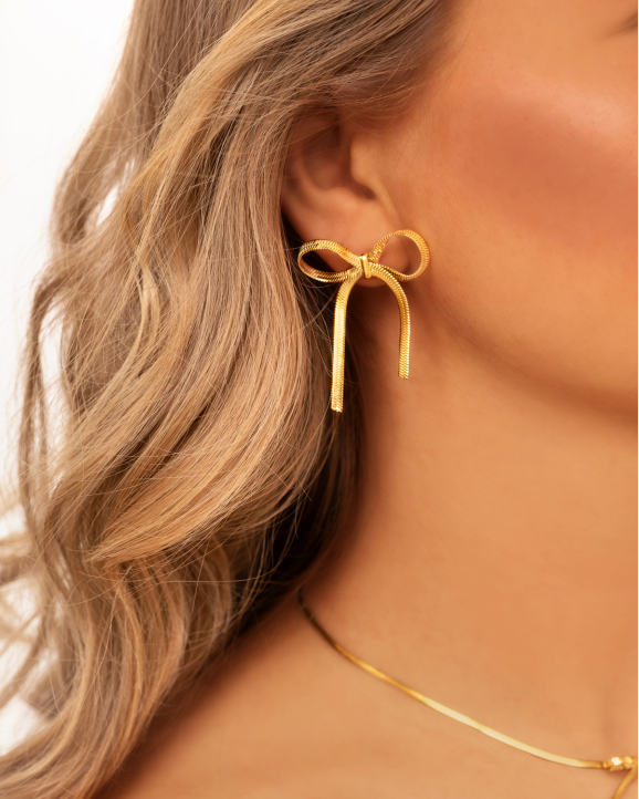 Gouden oorbellen met strikje in oor