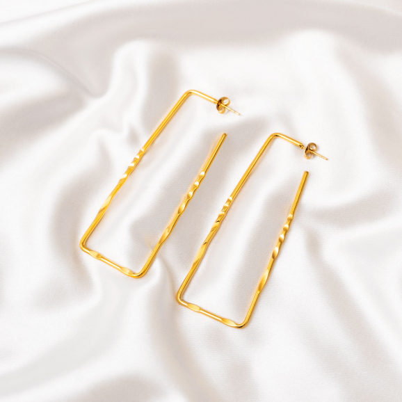Long statement earrings goudkleurig op wit satijn