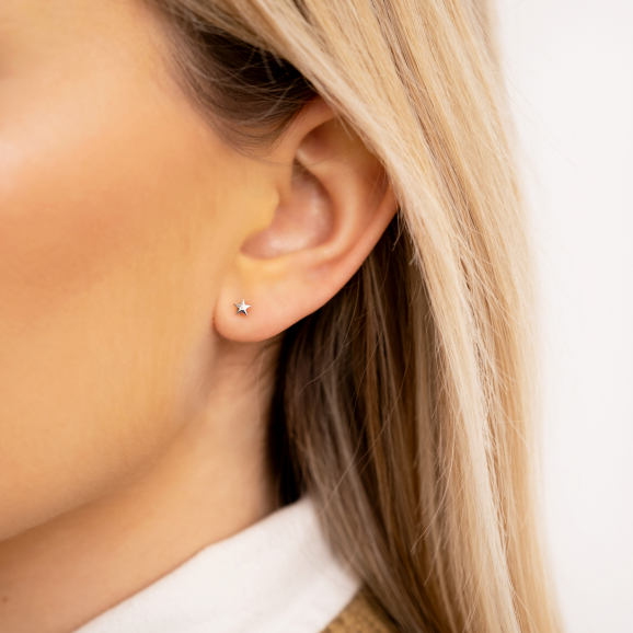 Model draagt Ster stud oorbellen in oren