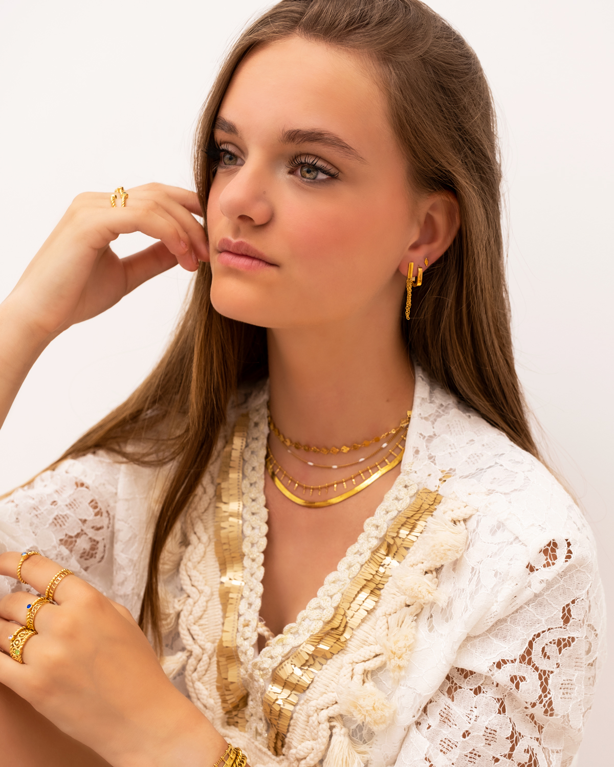 Model draagt look van gouden sieraden