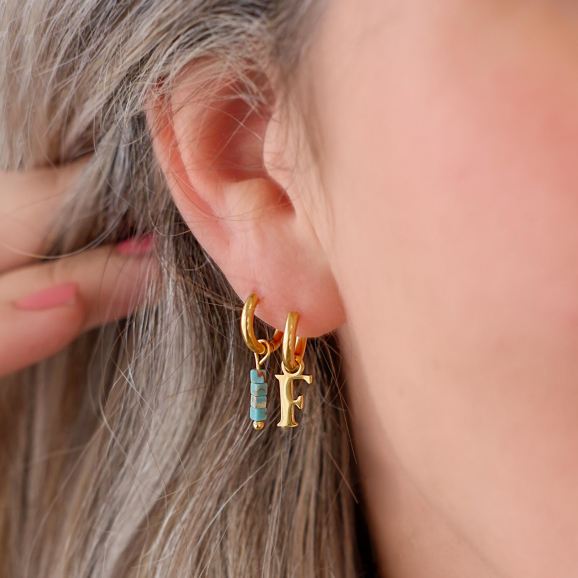 Trendy oorbellen met letters in het oor