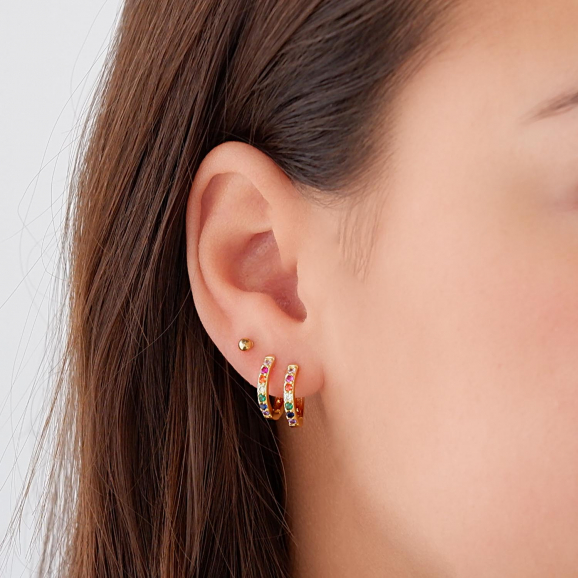 Gouden oorknopjes in het oor met oorringetjes 