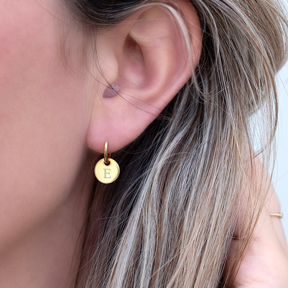 Gouden graveerbare initial oorringetjes in het oor met letter