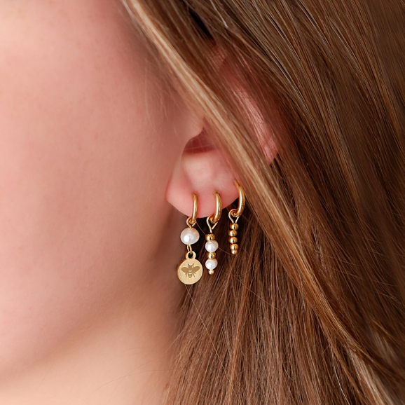 Trendy parel oorbellen in het oor voor een complete look