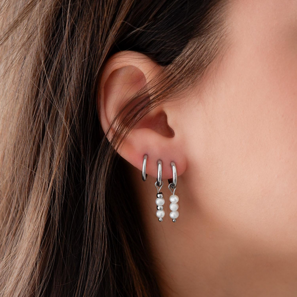 trendy oorbellen met parels in het oor voor een complete look