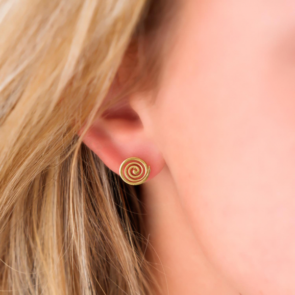 Stud oorbellen met patroon in het oor bij een blonde vrouw