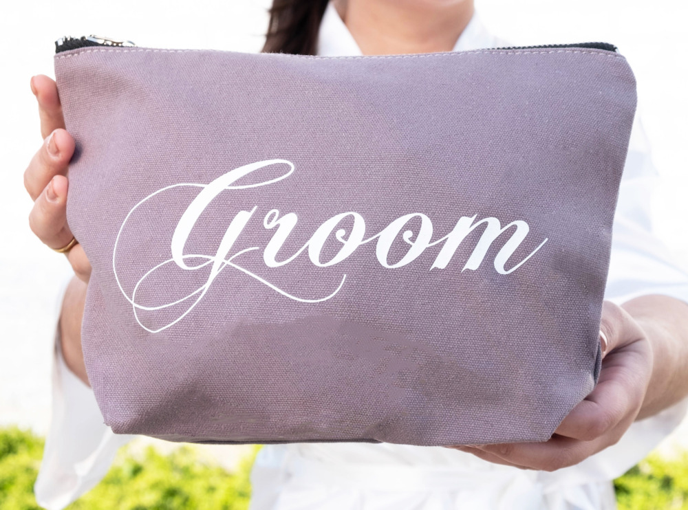 bruid houdt groom toilettas voor de bruidegom vast