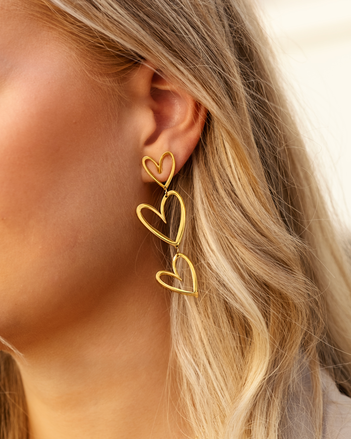 Oorbel met drie gouden hartjes