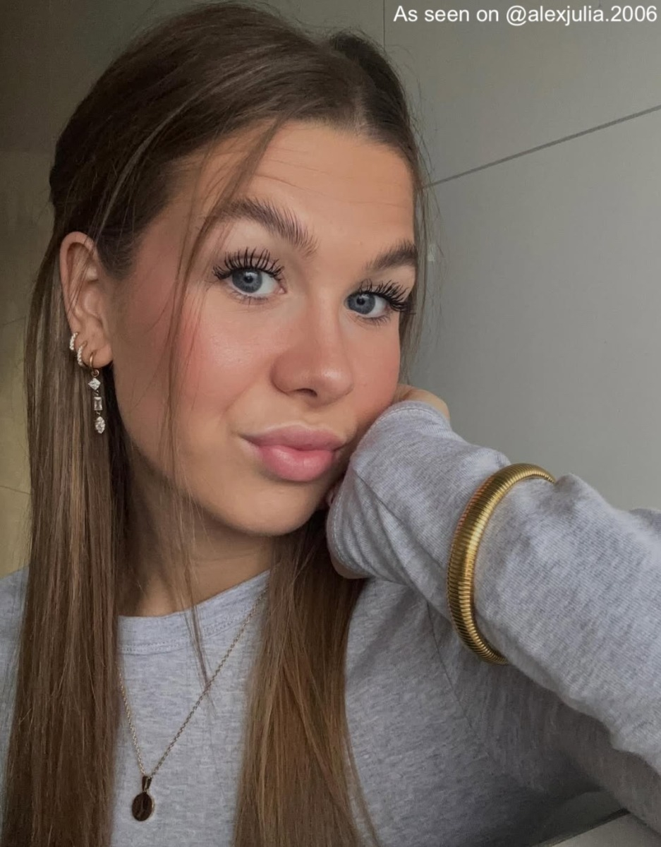 Influencer draagt gouden oorbellen met hanger
