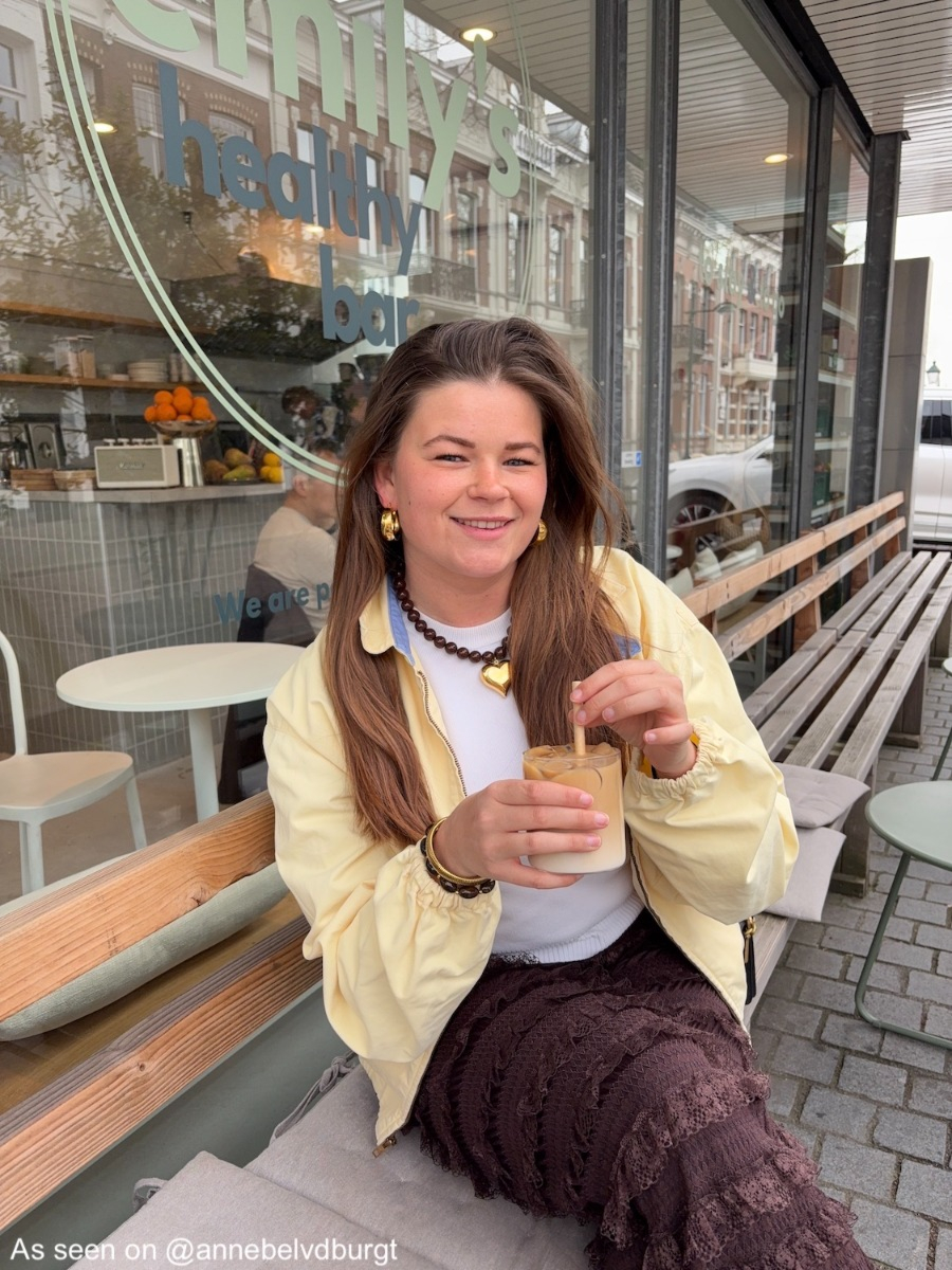 Influencer draagt bruine kralenketting met gouden hart
