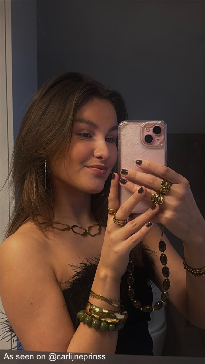 Influencer heeft bruine kralen telefoonkoord aan haar telefoon