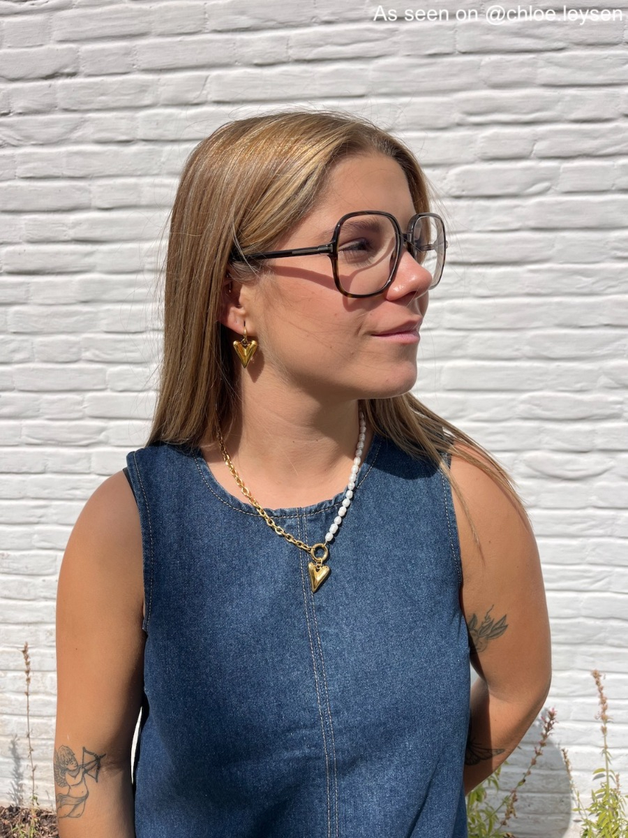 Influencer draagt gouden oorbel met hartje
