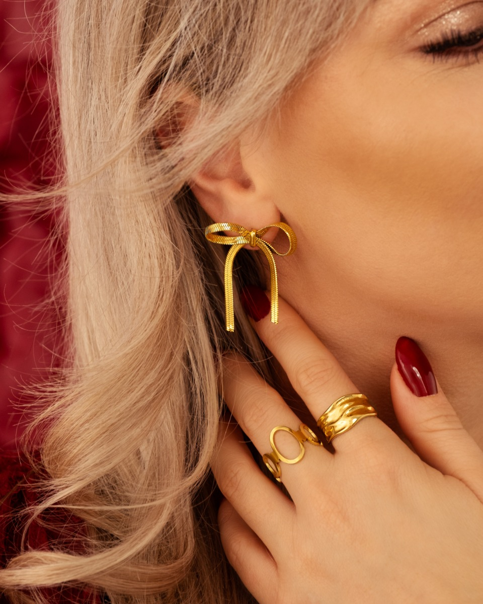 Gouden oorbellen en ringen mix bij model