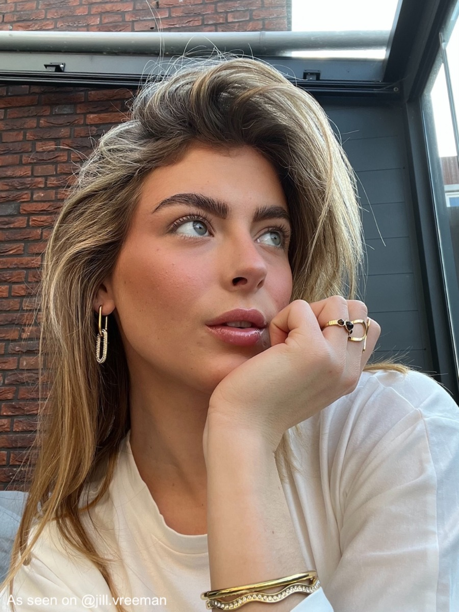 Influencer draagt gouden bangle met steentjes