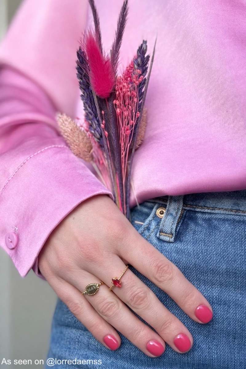 Influencer draagt gouden ring met roze steen