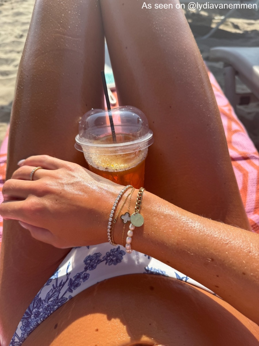 Influencer draagt gouden armband met parels en armparty
