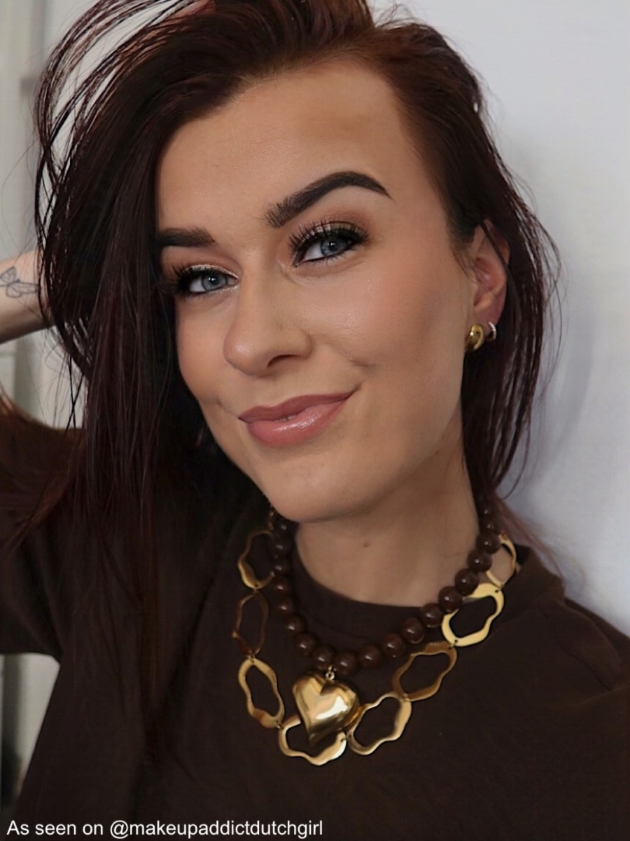 Influencer draagt bruine kralenketting met goud hart