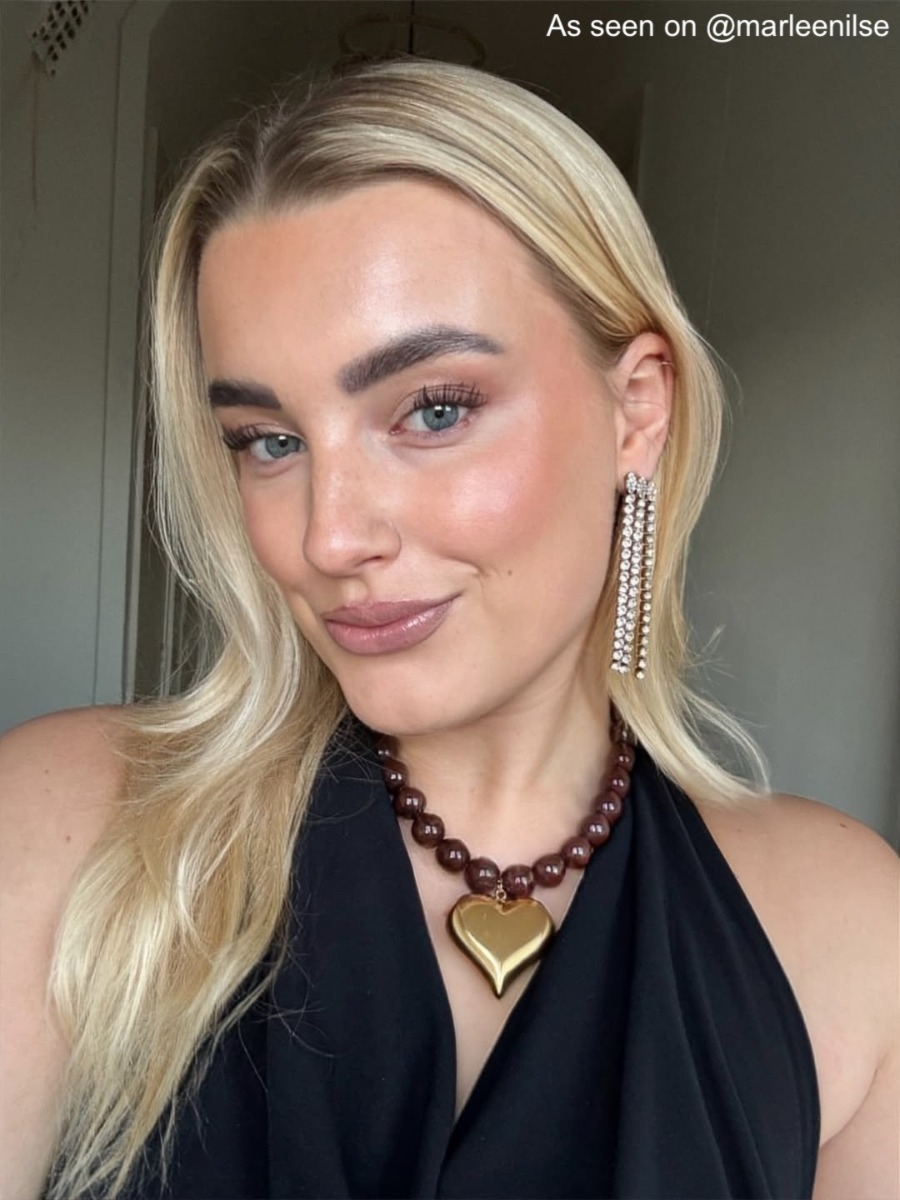 influencer draagt bruine kralen ketting groot goudkleurig hart