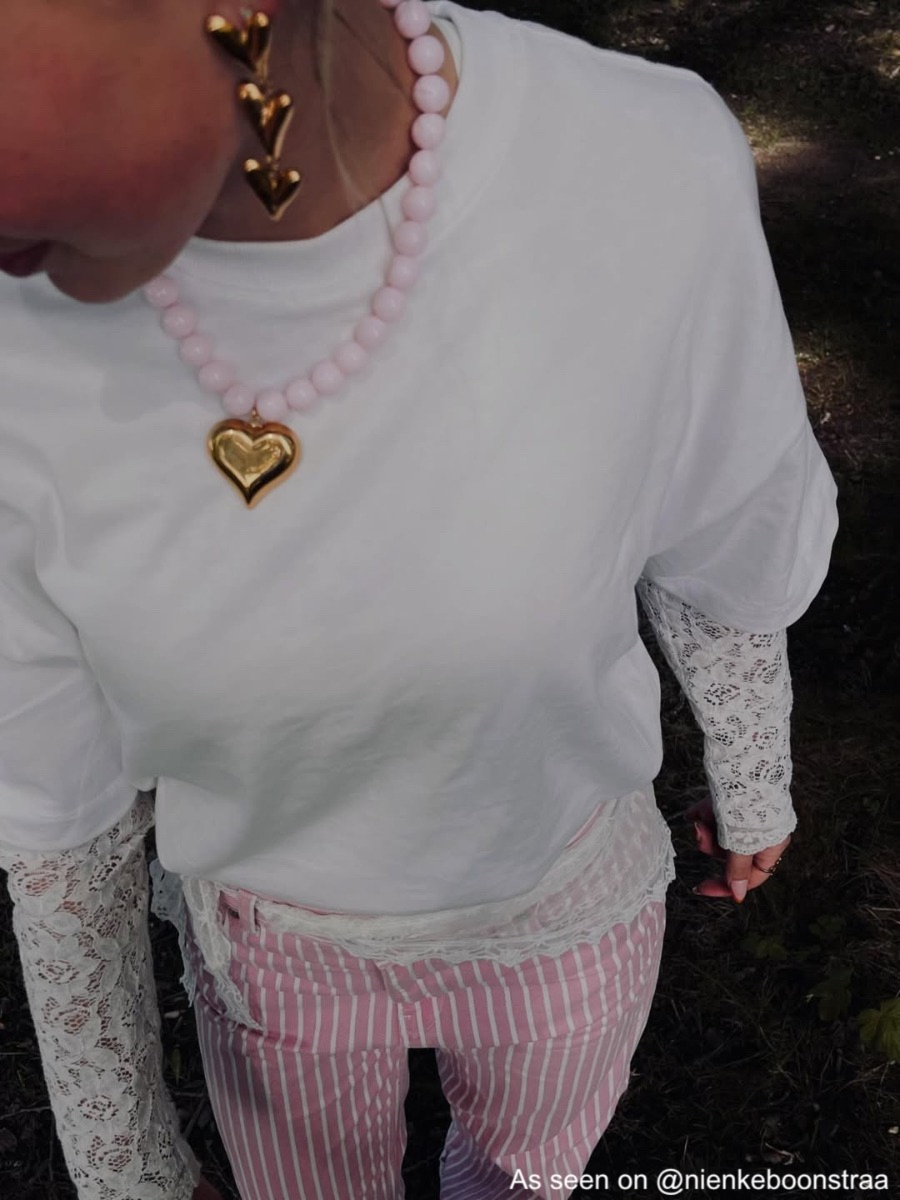 Influencer draagt lichtroze kralen ketting met gouden hart