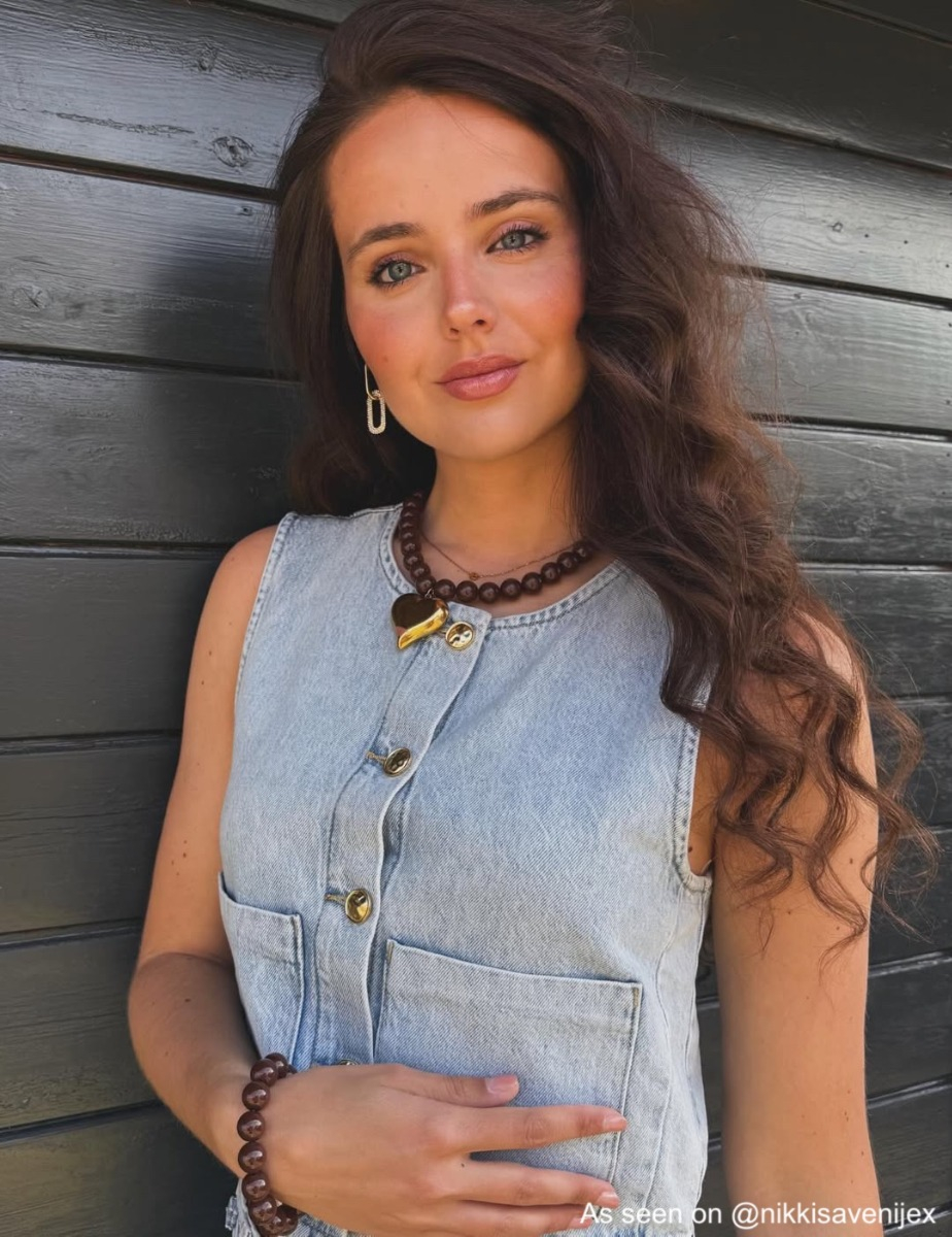 Influencer draagt bruinen kralenketting met gouden hart