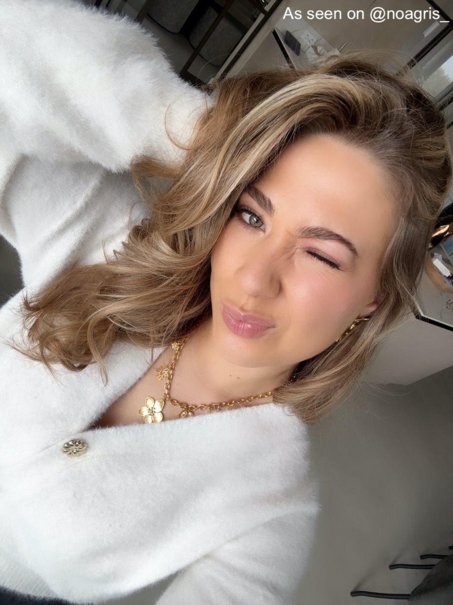 Influencer draagt een gouden bloem bedelketting met bijpassende oorbellen