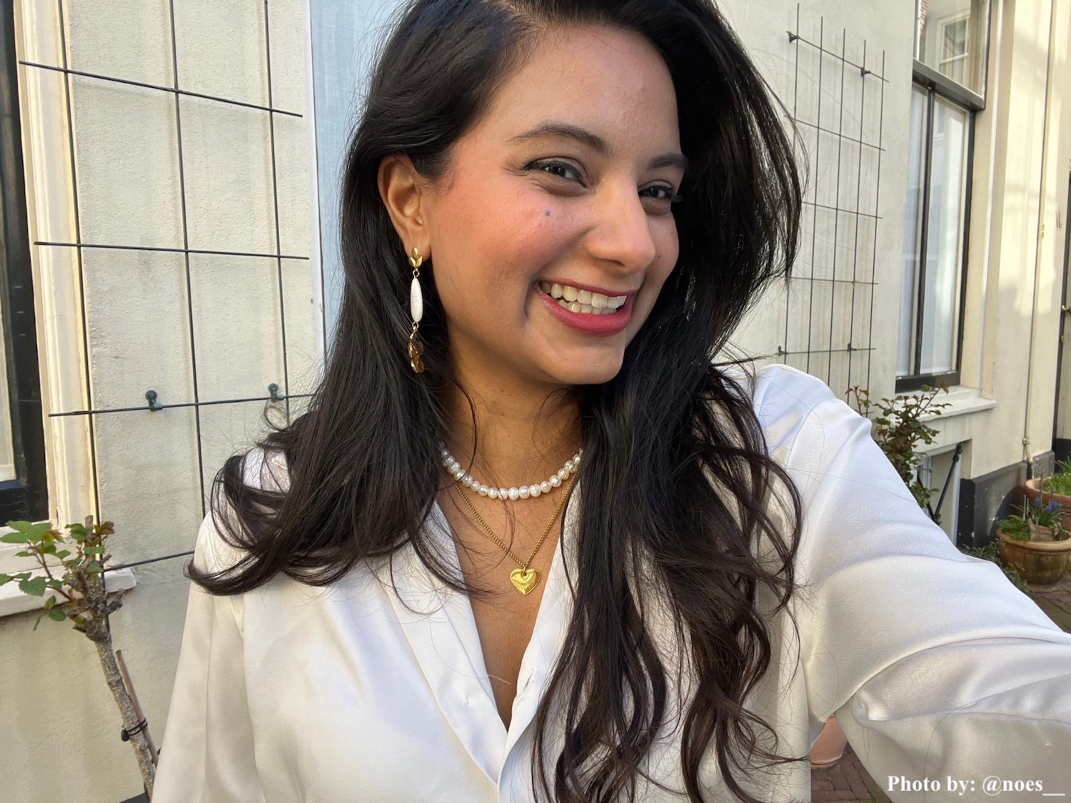 Influencer met witte druppel bloem oorbel.