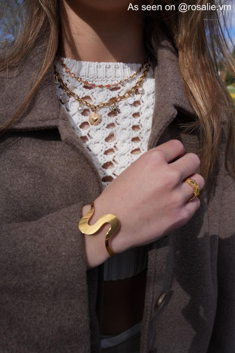 Influencer met gouden bangle, ring en 2 kettingen