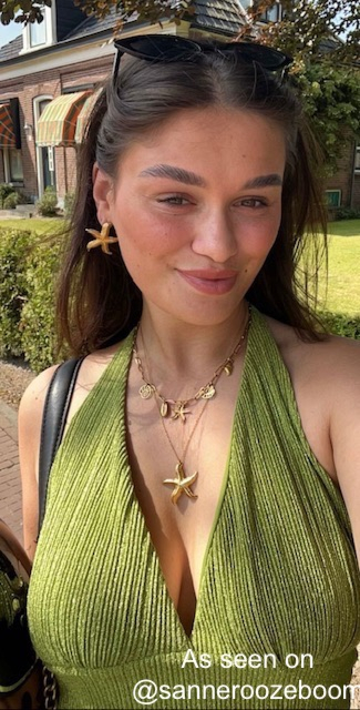 Influencer met gouden bedelketting met schelpjes