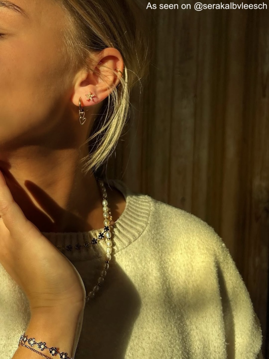 Influencer draagt gouden oorbellen met twee hartjes