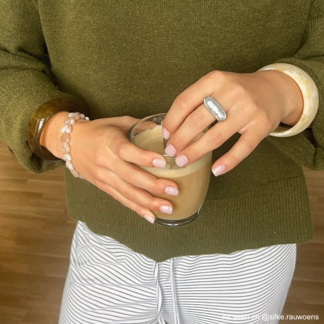 Influencer draagt beige hartjes armband
