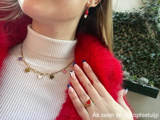 Influencer met gekleurde hartjes sieraden
